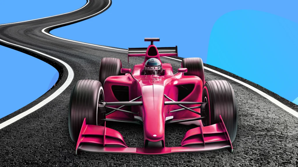 A red racecar is zooming toward the front of the image on a black track with a blue and purple backdrop. 