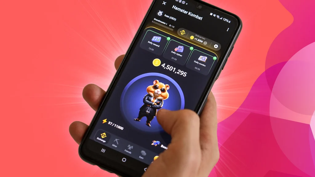 Someone holds up a phone over a dark pink background. On the phone is the Telegram mini-game called “Hamster Kombat,” showing a Hamster dressed in a tux with its arms crossed. 